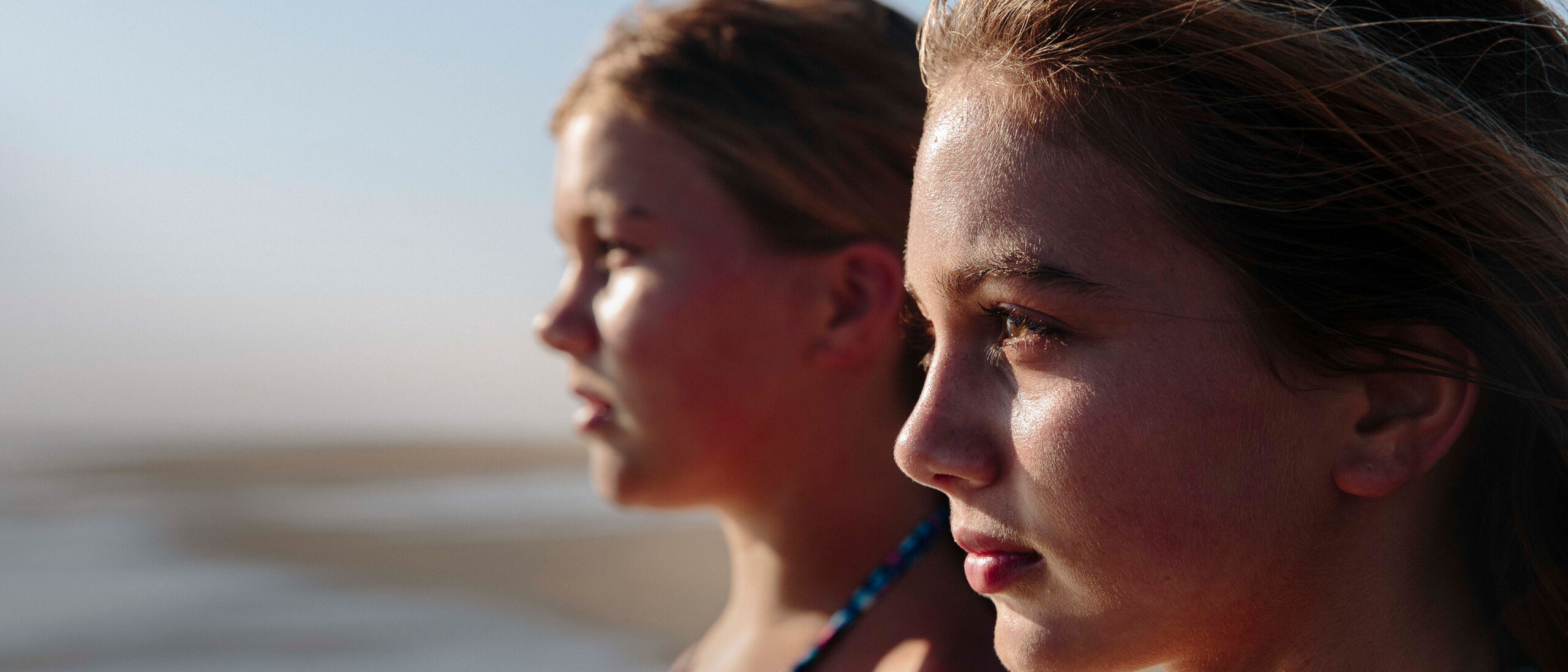 Two faces looking out into horizon over beach